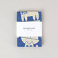 blue and white "kitchen cats" tea towel wrapped in paper band packaging 