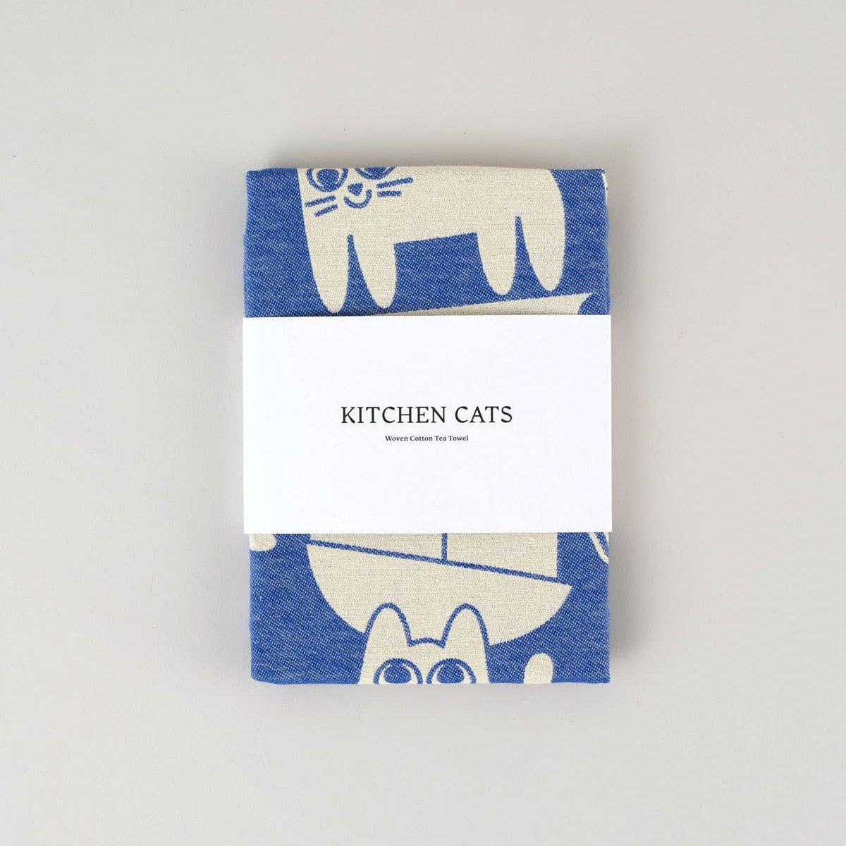 blue and white "kitchen cats" tea towel wrapped in paper band packaging 