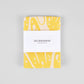 yellow "go bananas" kitchen towel wrapped in paper band packaging