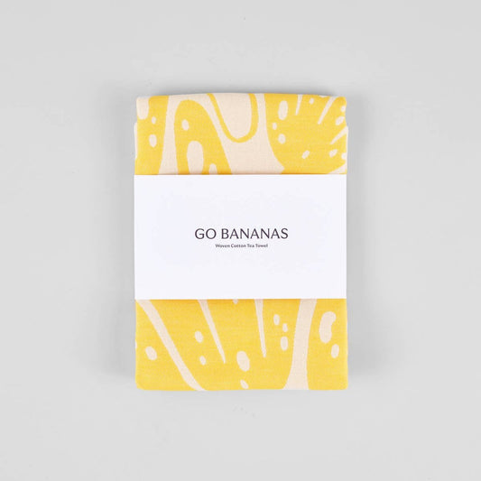 yellow "go bananas" kitchen towel wrapped in paper band packaging