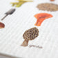 Close up of a watercolored morel mushroom and the artist's name "Yardia" on a sponge cloth.
