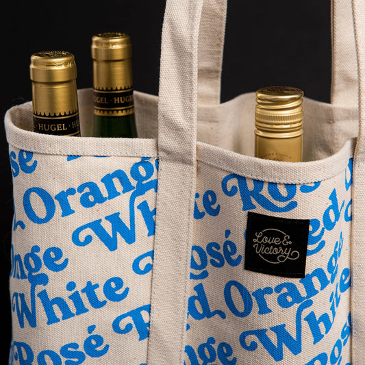 Wine Bottle tote bag with blue print. Repeat pattern that says White, red, rosé and orange.