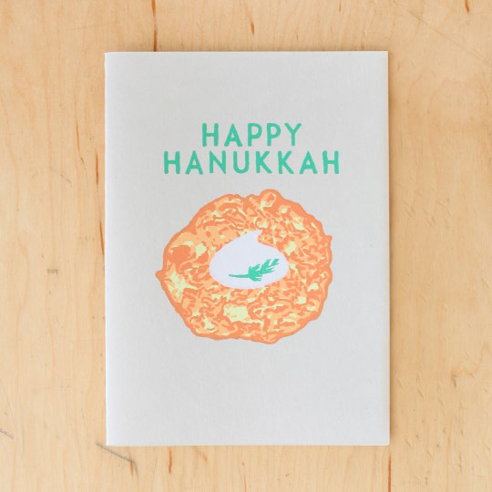 Greeting card that reads "Happy Hanukkah" and has the image of a latke with sour cream on it 