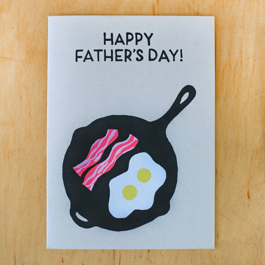 Card reads "Happy Father's Day!" and has illustration of bacon and eggs in a cast iron frying pan 