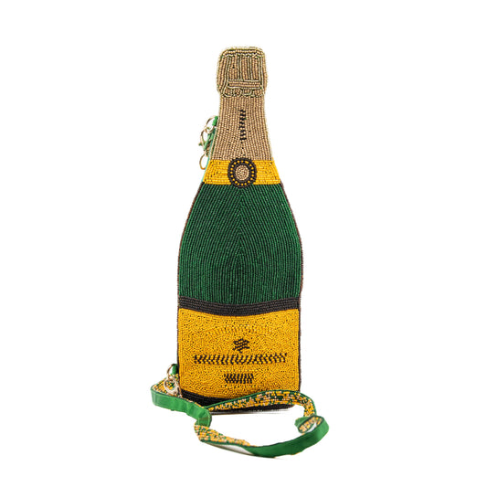 Photo of beaded purse shaped like a champagne bottle displayed on a plain white background. Beaded design depicts green bottle with yellow and blue nondescript wine label and gold foil at the top of bottle. Attached to purse is a green and gold beaded purse strap resting mainly in the foreground.