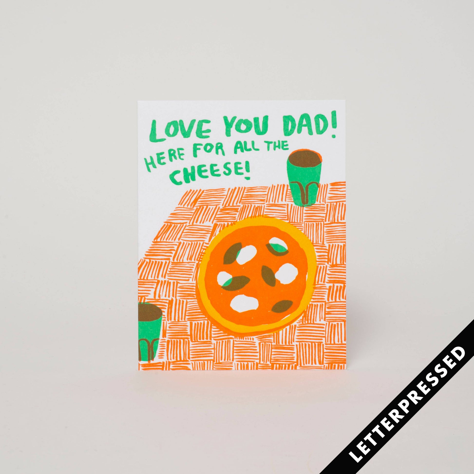 Father's day card that reads "Love you Dad! Here for all the cheese" and has imagery of a table with two cups and a cheese pizza on it. 