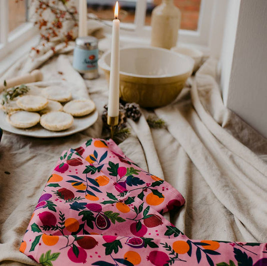 Pink botanical fruits kitchen tea towel on table setting 