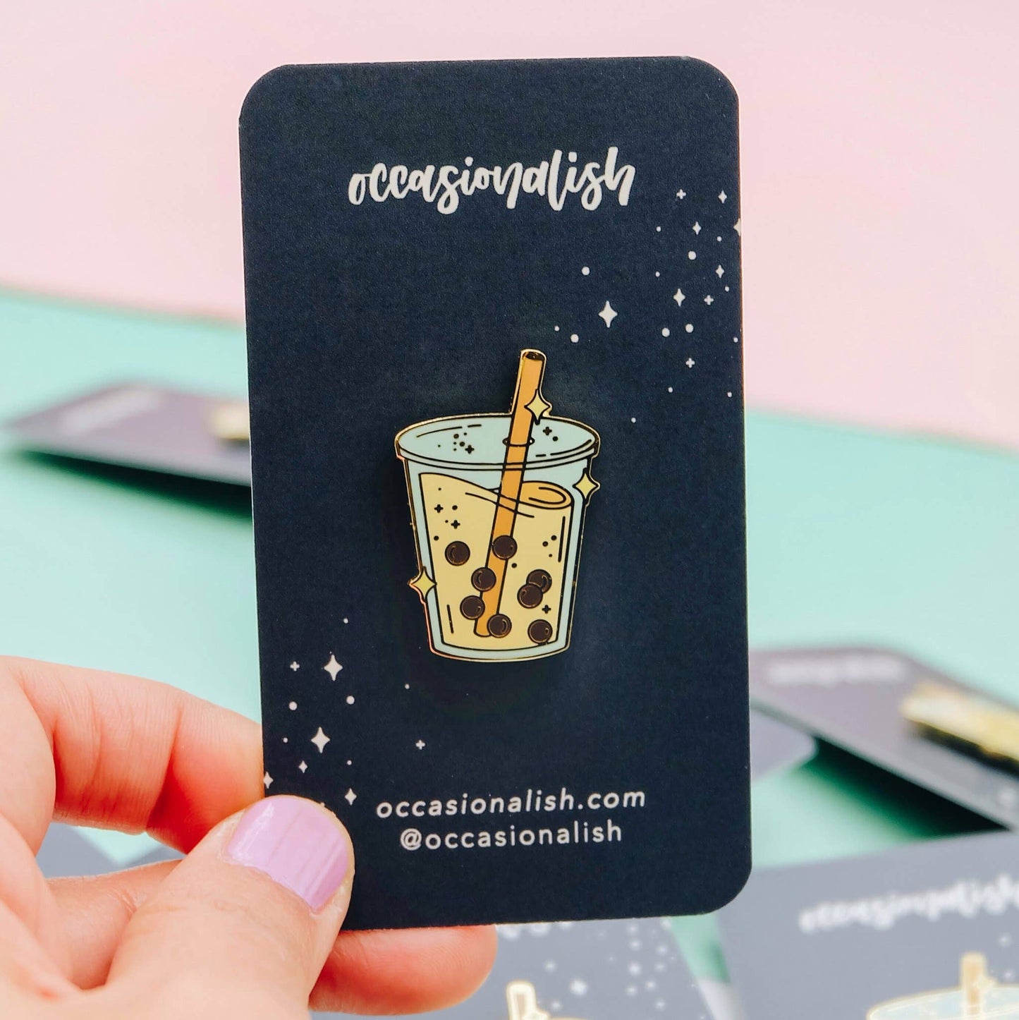 Boba Lapel pin with an orange straw and sparkles. The pin is on a navy card backing with Occasionalish logo.