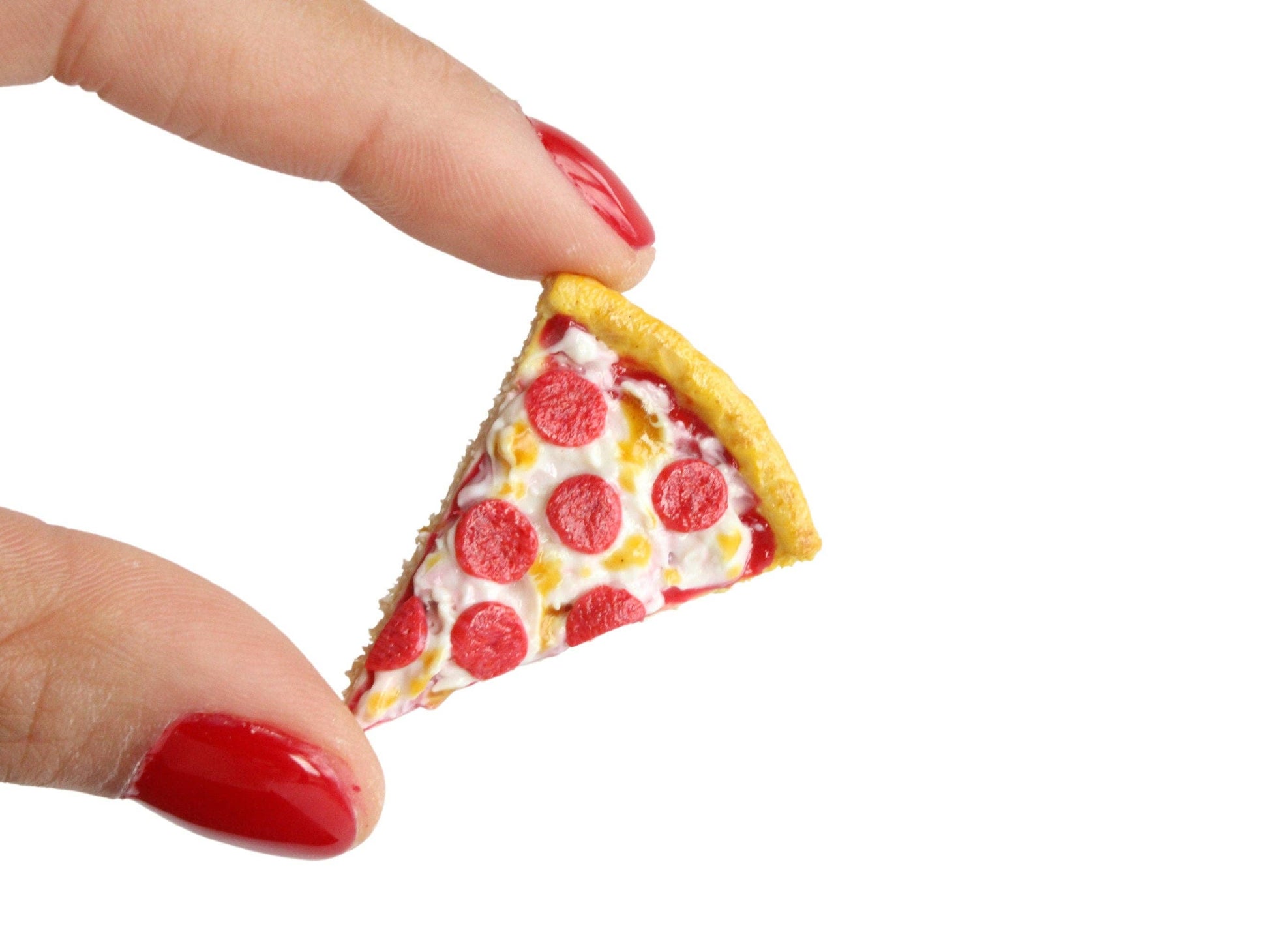 Handmade magnet shaped like a single slice of pepperoni pizza. Shown held between two fingers for size comparison.