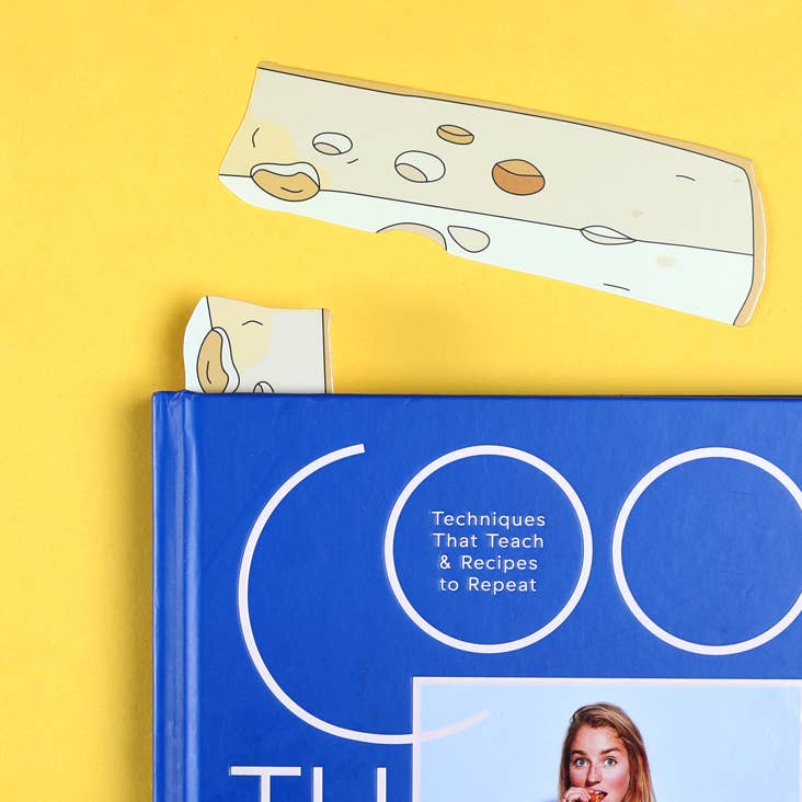 Block of cheese bookmarks -- one peeking out from inside a book and the other placed above it 