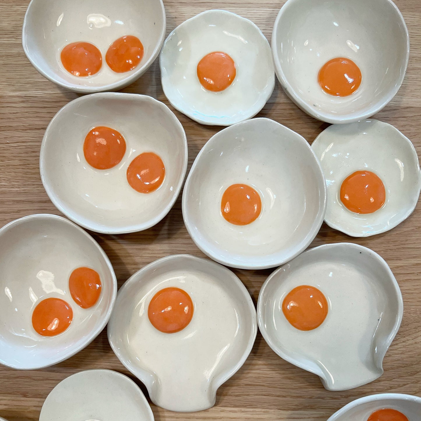 Handmade egg saucers, bowls and spoon rests with both one and two yolks 