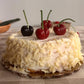 4 Realistic Cherry Candles on a white cake with white chocolate shavings
