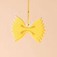 A car air freshener made to look like farfalle (bowtie) pasta. Lemon scented. 