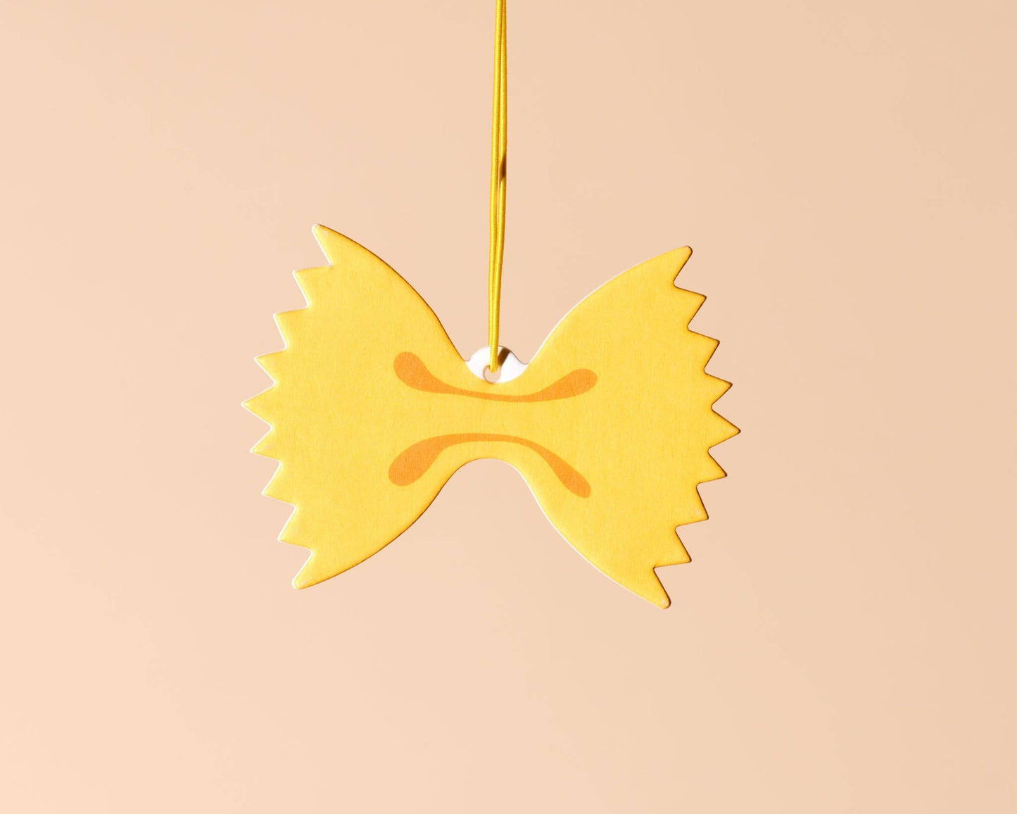 A car air freshener made to look like farfalle (bowtie) pasta. Lemon scented. 
