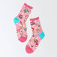 Pink, sheer, women's crew socks -- mostly pink with turquoise heel. Patterned with various sweet treats -- cakes, ice cream, mikshakes and candy.  