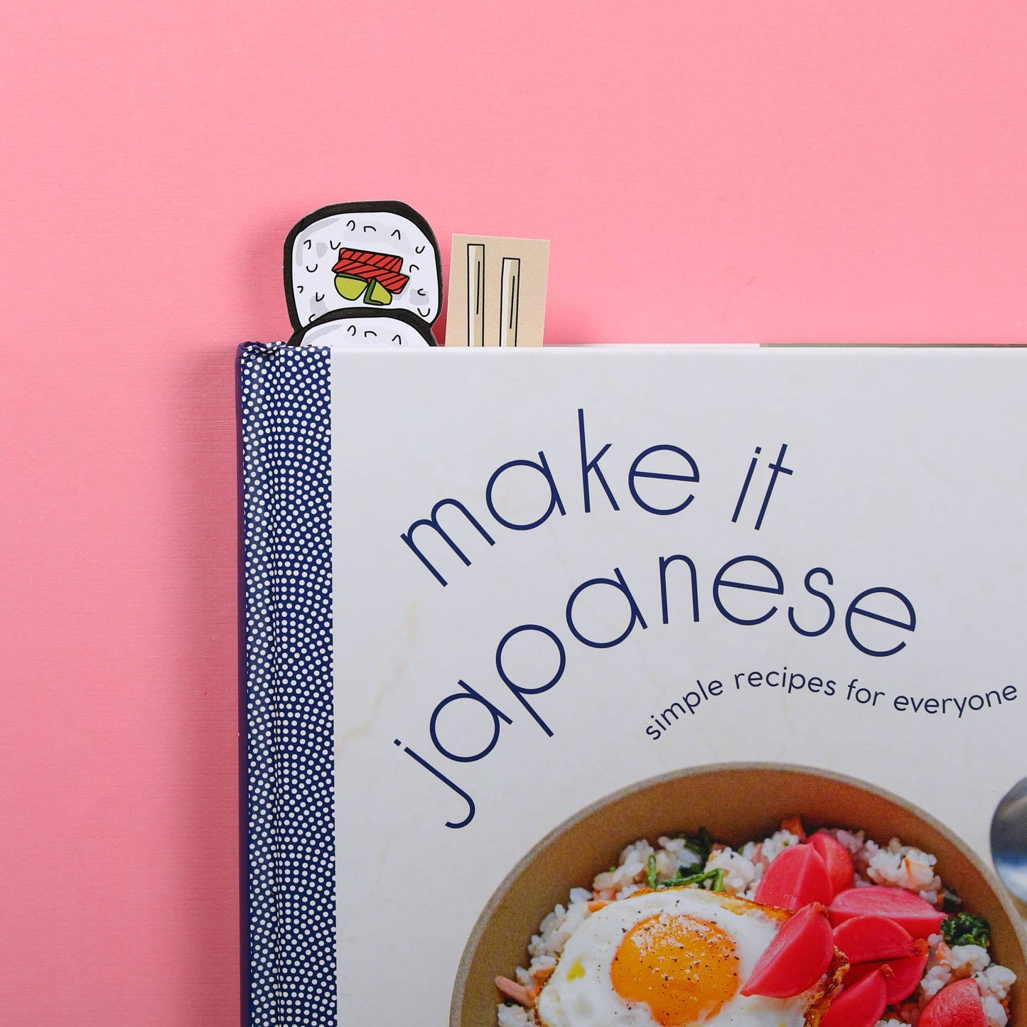Sushi and chopstick bookmarks peeking out from book 