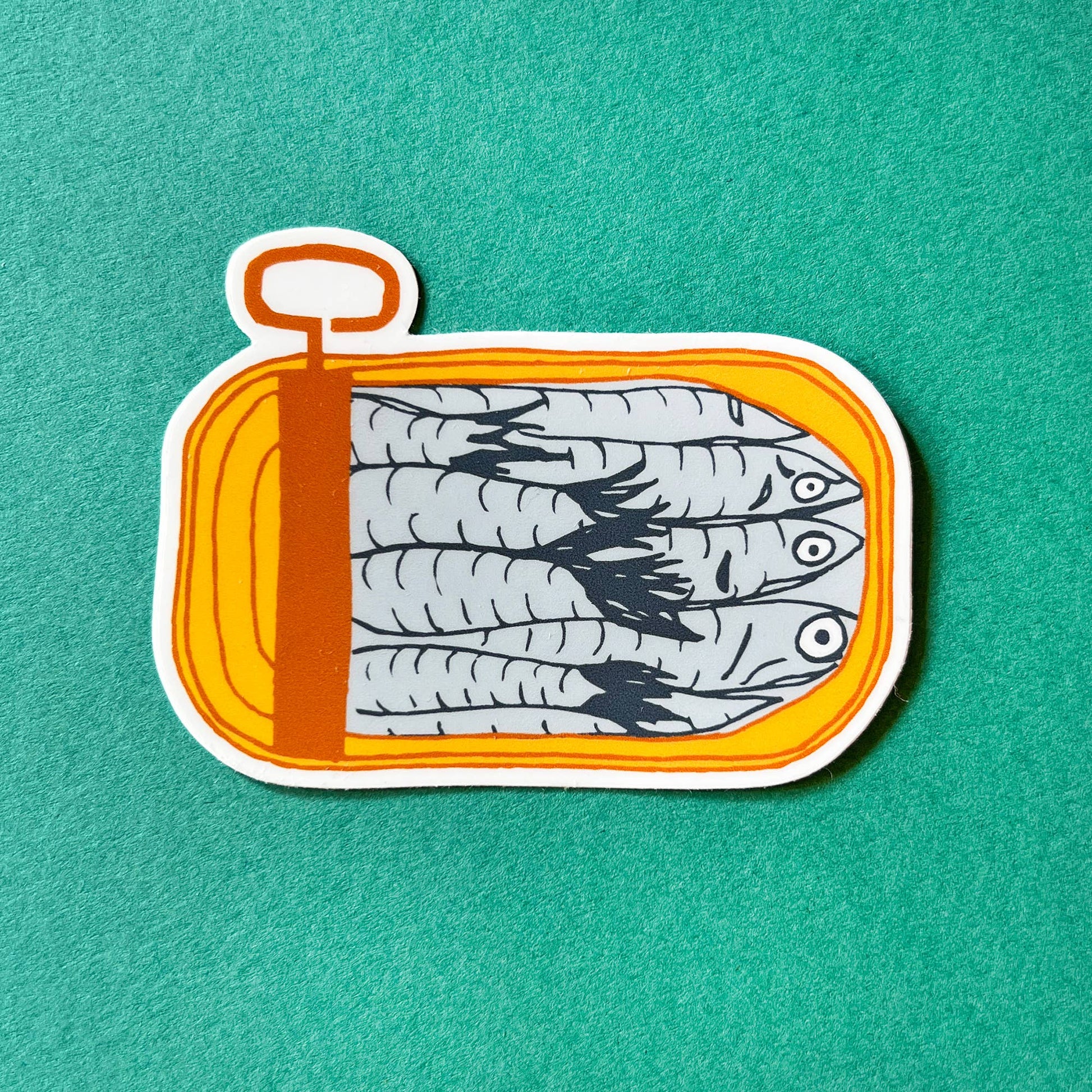 Matte sticker with illustration of an opened, mustard yellow, tinned fish can with packed sardines inside 