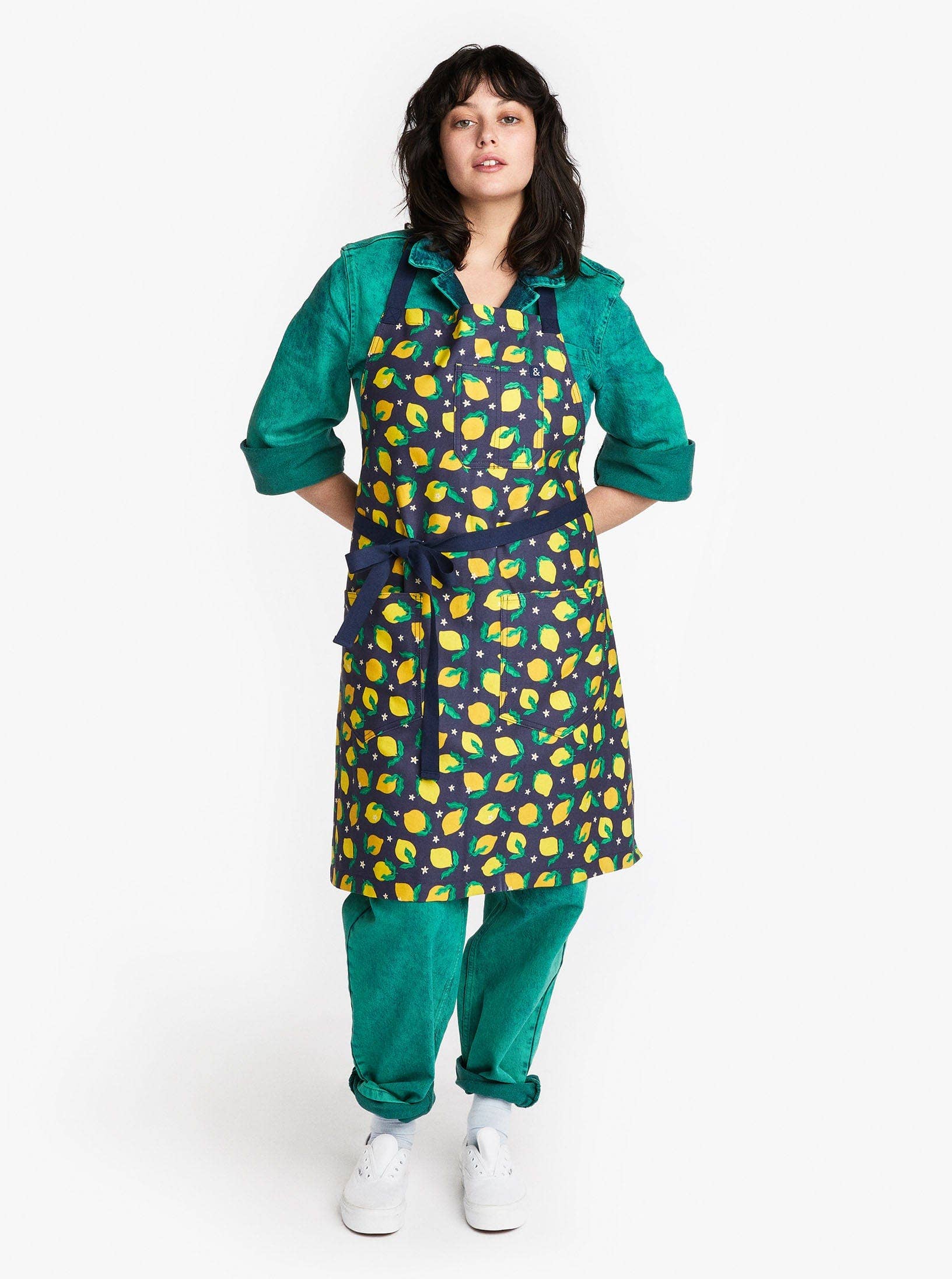 Apron worn on model -- apron is dark blue with lemons all over 