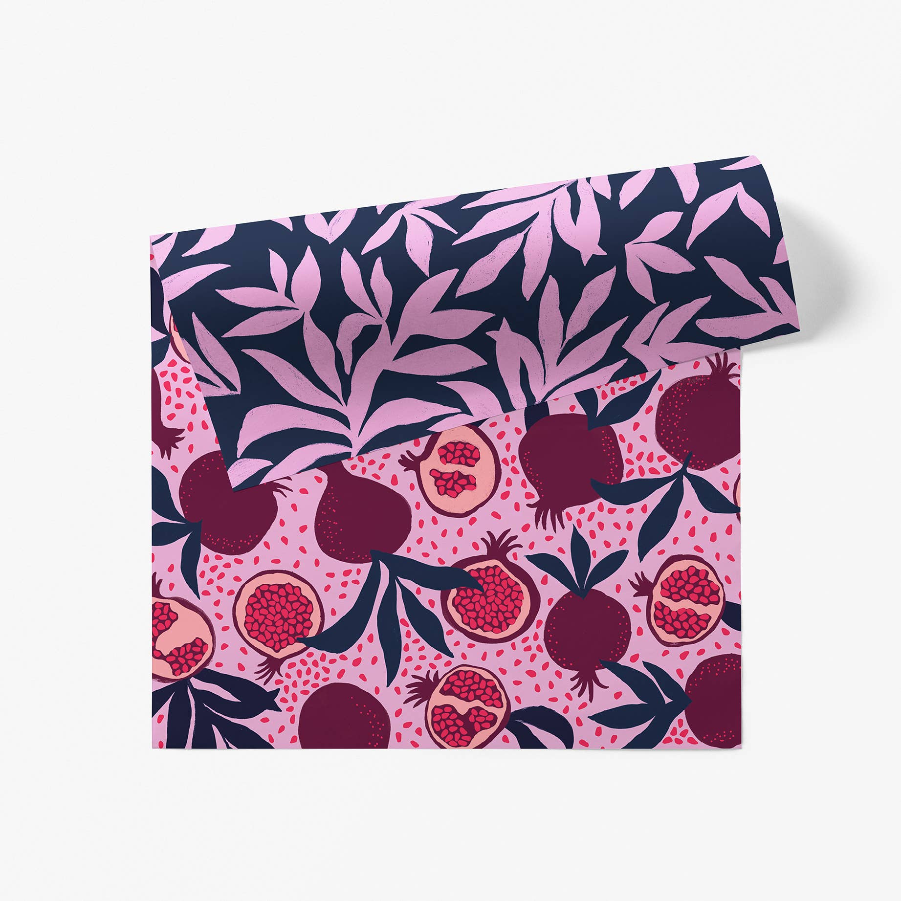 Sheet of double sided wrapping paper -- one side is fucshia with pomegranates on it, the other is navy with purple foliage. 