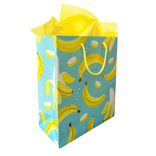 Seafoam green gift bag with whole and sliced yellow bananas on it and yellow string for the handle  