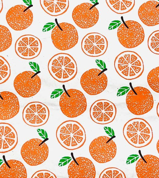 Single sheet of gift wrap with whole and cut oranges as the design