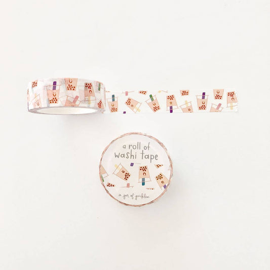 Washi tape with a white background and smiley boba cups all over as the design