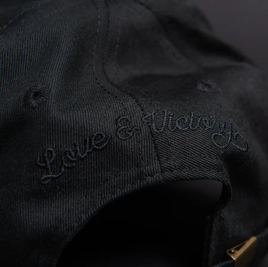 embroidery on back of hat reads "Love & Victory", the brands name.