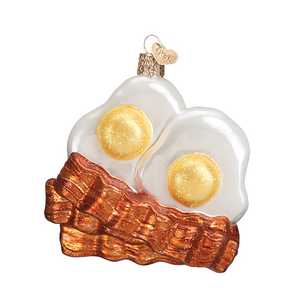 A single Christmas ornament of two sunny side up eggs and three pieces of bacon