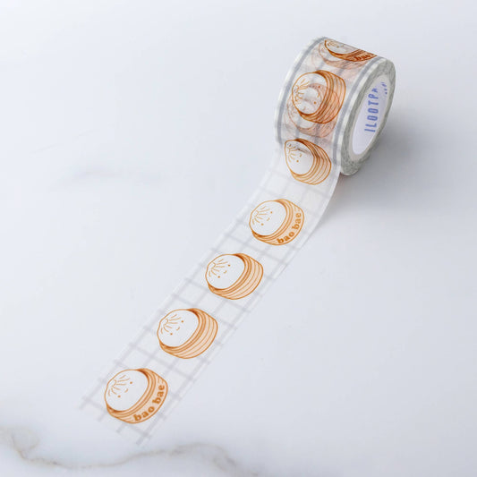 Washi Tape roll with repeat pattern of single bao with a sweet smile, sitting in a steamer. Every third steamer has the words "bao bae" on the side .