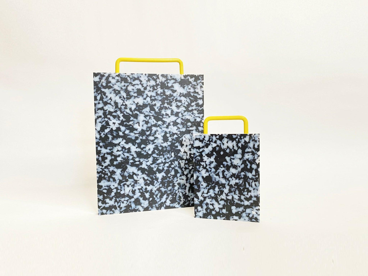 Cutting board is black and white, handle is yellow. 