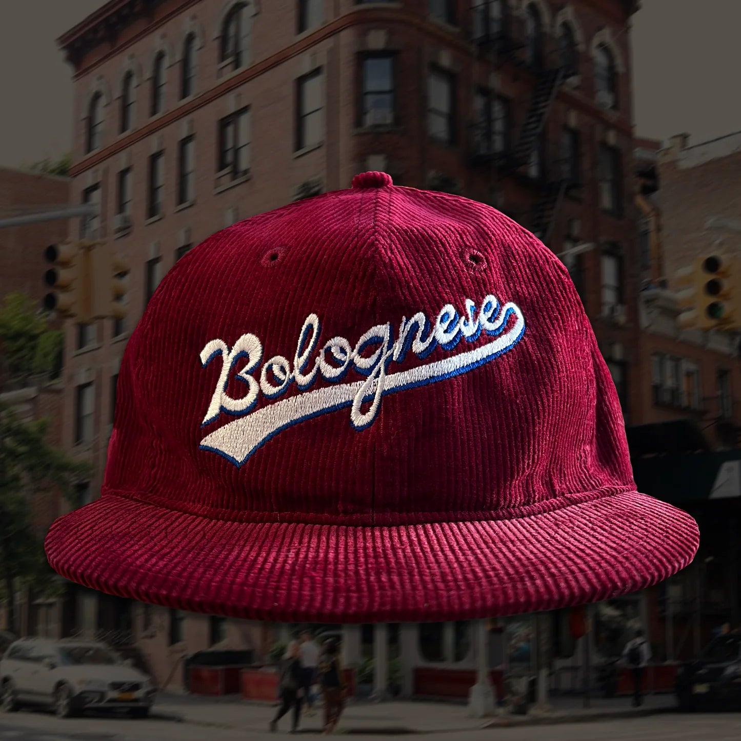 maroon corduroy cap that has "Bolognese" embroidered on the front 