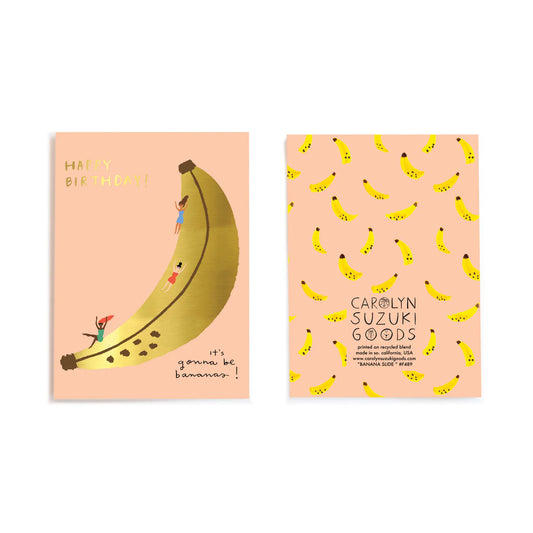 Side by side of the front and back of the greeting card --- front is pink with a gold foil banana in the middle with ladies sliding down it. Back of card has smaller, yellow bananas all over it. 