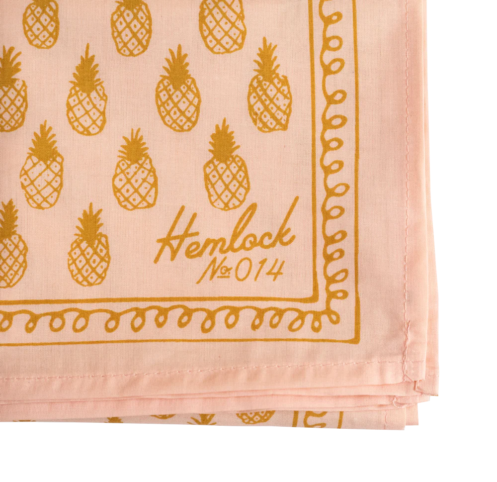 Close up of gold pineapples on light pink bandana 