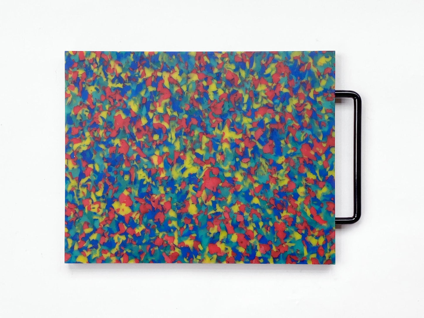 Rainbow cutting board that looks majority blue but has primary color confetti throughout. Handle is black. 
