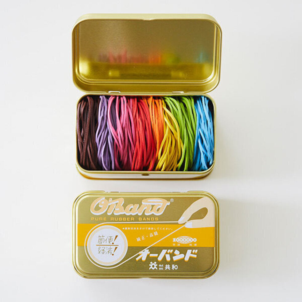 Tin can that has rubber bands in 8 different colors in it, approximately 200 total --  chocolate, violet, pink, red, orange, yellow, light green and light blue 
