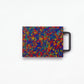 Small rainbow cutting board with yellow, red and blue confetti and black handle 