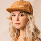 Tan colored, corduroy cap with "Tacos" embroidered on the front on model 