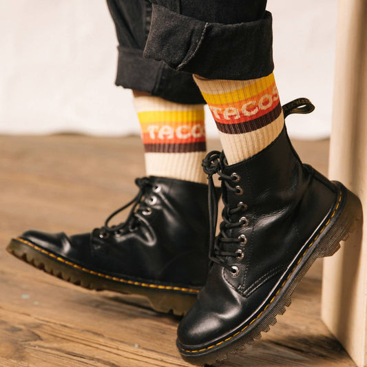 Tacos striped sock. Model is wearing Doc Martin boots and high black pants to show off the socks.