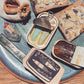 Flat lay of tinned fish candle -- comes packaged like real tinned fish 