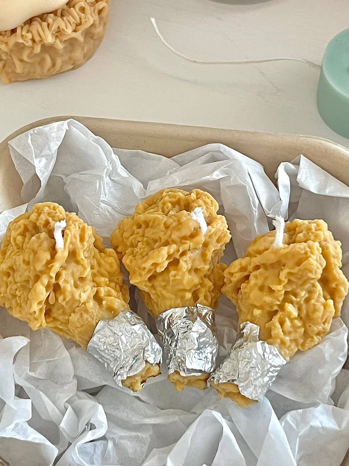 Set of three decorative candles that look like crispy fried chicken.