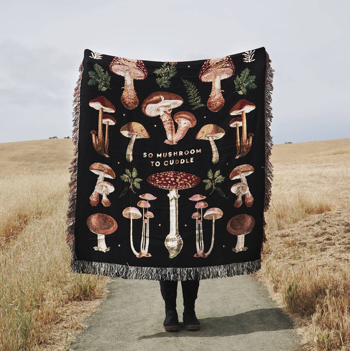 Mushroom throw blanket with various mushrooms and foliage on it with text that reads "So Mushroom To Cuddle" 