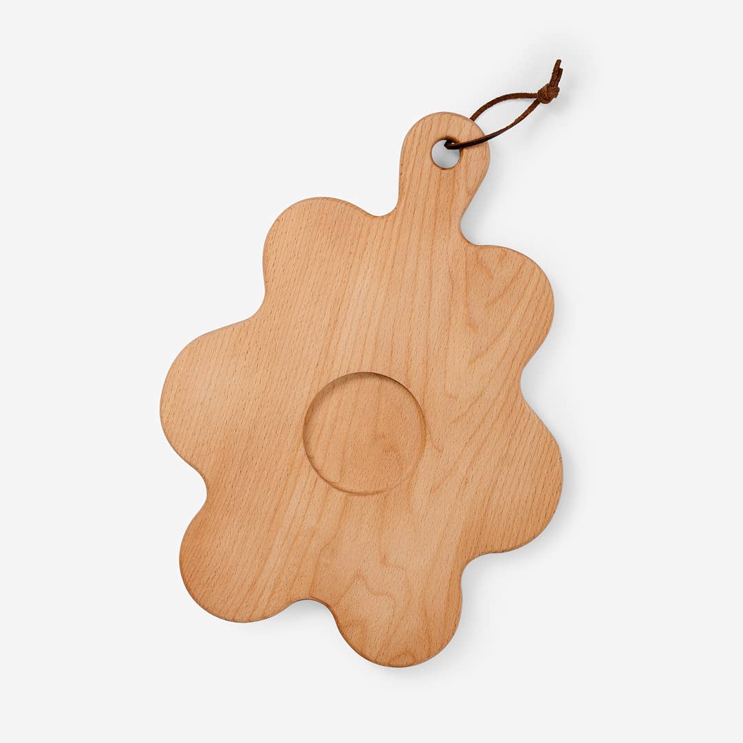 Wooden board shaped like a flower with indent in middle for small bowl 
