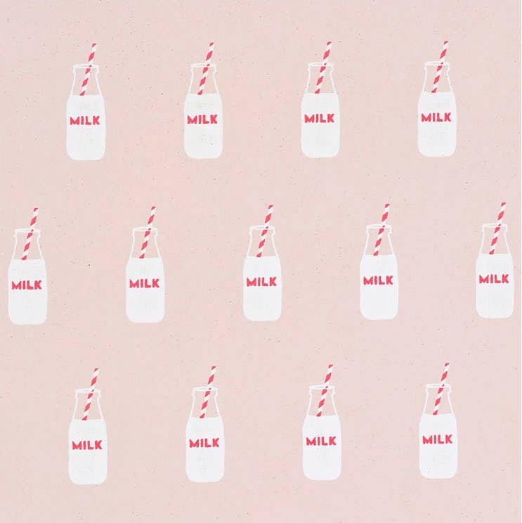 Milk bottle gift wrap with bottles 3/4 full with milk. The bottles say milk and there is a red and white straw sticking out of the bottle. Pink background.