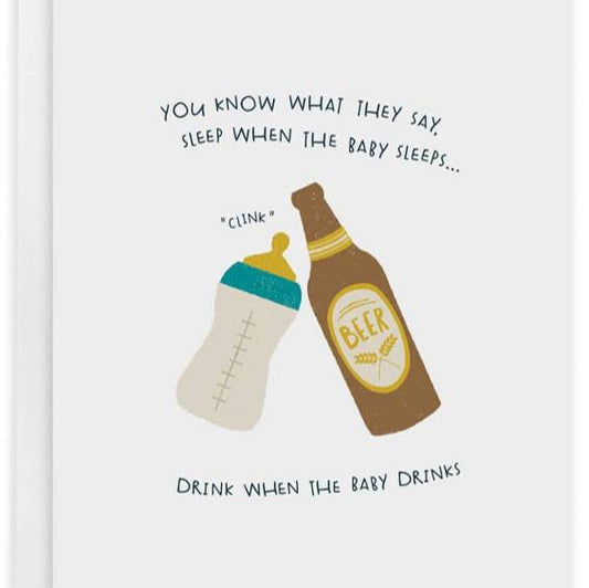 Baby greeting card that reads "You Know What They Say, Sleep When The Baby Sleeps...Drink When The Baby Drinks" and has an image of a baby bottle and beer bottle clinking together 