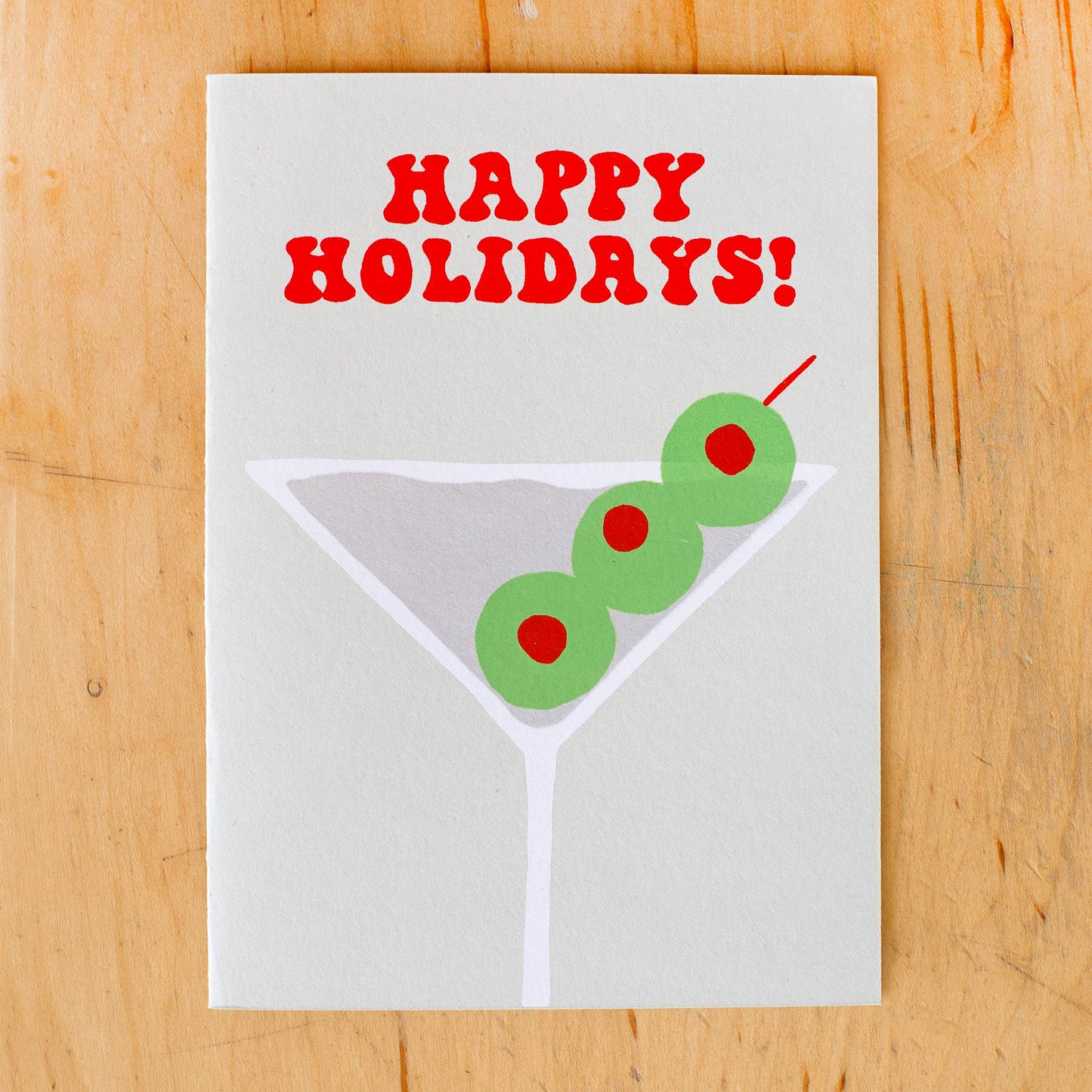 Greeting card that reads "Happy Holidays!" on top and has an image of a martini glass with 3 olives in it 