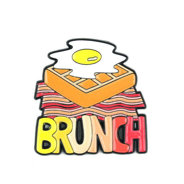 Enamel pin that reads "Brunch" below an egg, waffle and three pieces of bacon
