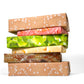 Stack of six boxes wrapped in cheeseburger wrapping paper, each box corresponding to a component of a cheeseburger. From top to bottom -- Bun wrapping paper, tomato wrapping paper, lettuce wrapping paper, cheese wrapping paper, patty wrapping paper and bun wrapping paper. 