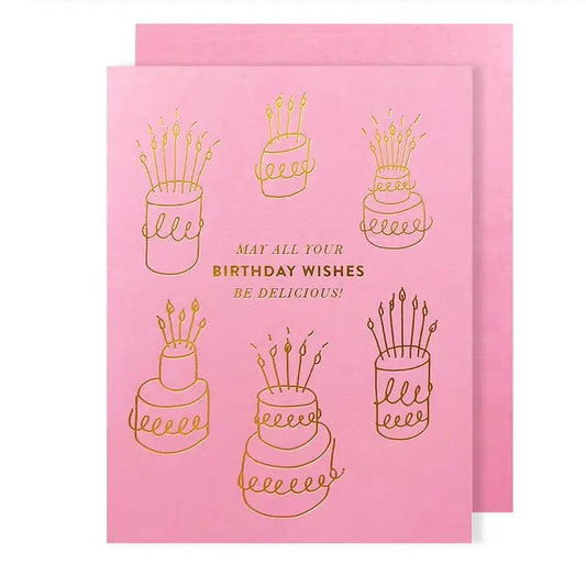 Pink card with gold foil, imprinted cake and text design on front. Text reads "May all your birthday wishes be delicious!" 