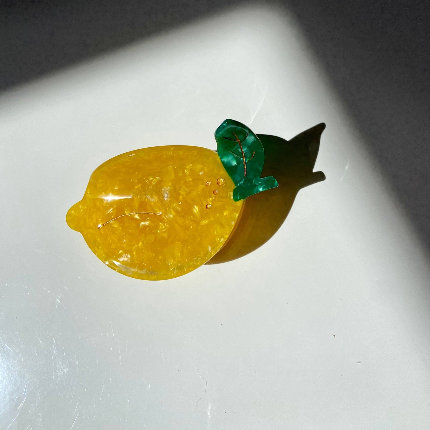 Hair claw/clip made to look like a lemon -- made of acetate; leaves are green with gold accents, body is yellow