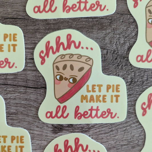 Sticker with an illustrated slice of pie on it. Text reads "shhh...let pie make it all better" 